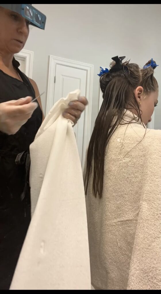 Louse Calls technician providing professional in-home head lice removal for a client